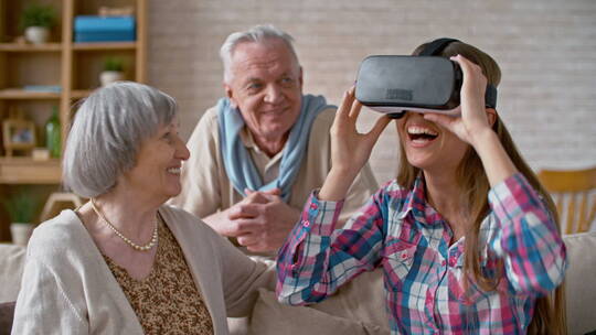 和祖父母玩虚拟眼镜的女人