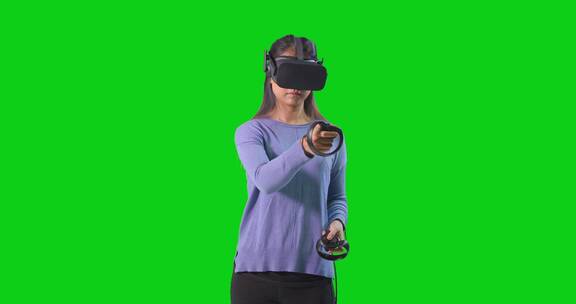 女人在绿色背景玩虚拟游戏