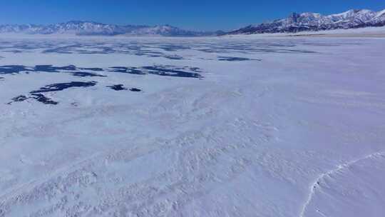 航拍新疆冬季赛里木湖冰封湖面雪山冰湖积雪