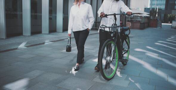 女人在城市里推自行车 