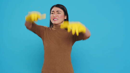 带着防护手套的紧张的亚洲家庭主妇在房屋清洁方面有问题视频素材模板下载