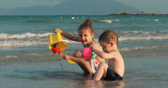 快乐无忧无虑的孩子们在海边玩沙子