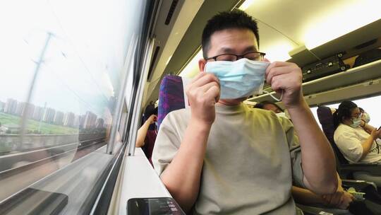 中年男性乘客高铁上带上口罩
