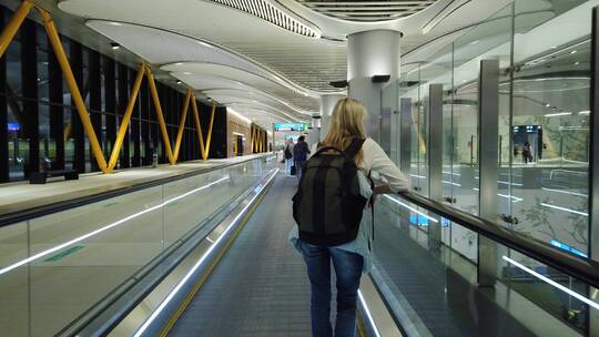 国际机场自动扶梯上的女人
