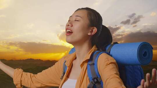 亚洲女性徒步旅行者在山顶张开手臂的特写侧