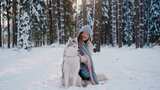带着宠物狗在落满雪花的森林散步高清在线视频素材下载