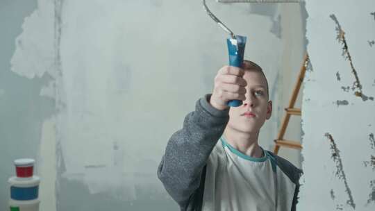 青少年使用滚筒用白色油漆绘制玻璃视频素材模板下载