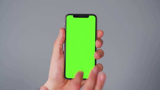 拿着一只手机带有绿幕的