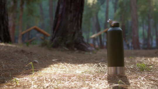 草坪上被提起来的保温瓶