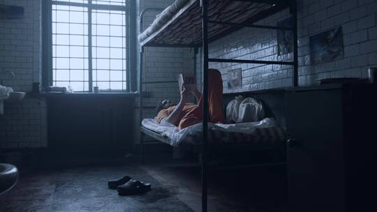 囚犯躺在床上在看书视频素材模板下载