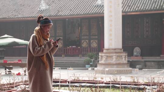 女孩走在成都大慈寺游览古迹看手机