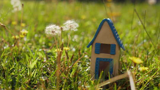 绿色草坪上的玩具屋是生态家园的象征
