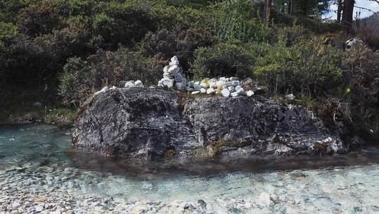 川西稻城林间小河流水边的尼玛石堆视频素材模板下载