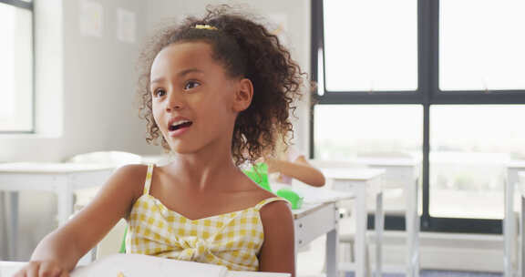 快乐多样的女孩坐在学校课桌前学习的视频