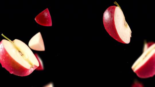 黑色背景下红色苹果和切片的飞行