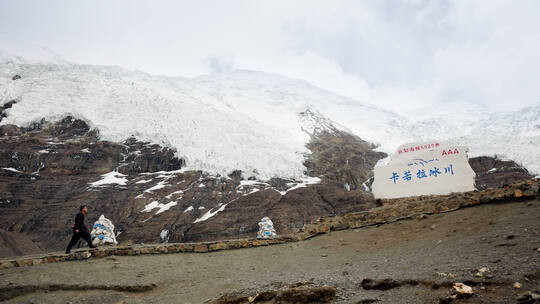 男人在卡若拉冰川山脚下行走1