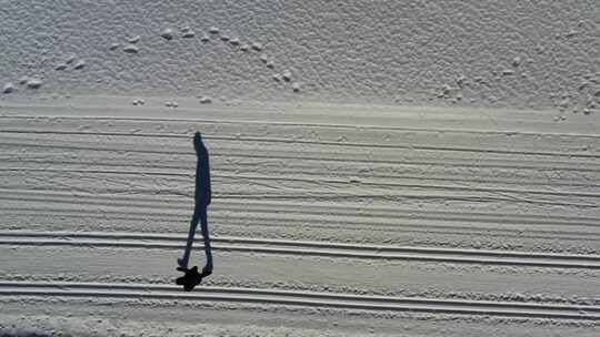 男人在雪地里行走的倒影