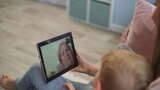 妈妈和孩子通过现代平板电脑与奶奶视频通话高清在线视频素材下载