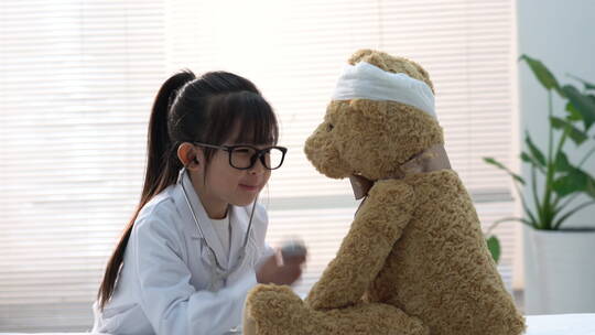 装扮成医生的小女孩给玩具小熊看病视频素材模板下载
