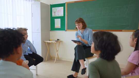 高加索年轻女子教师在学校教室教学生。