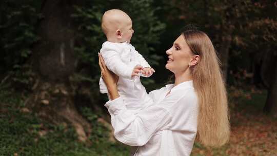 美丽的母亲在森林里抱着婴儿