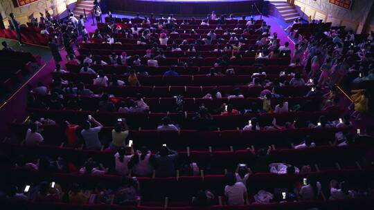 文艺汇演表演厅观众席上观看表演的人们