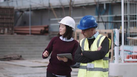 两名建筑师在工地上交流工程设计