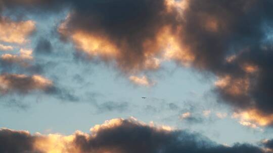 早霞云朵中飞机飞过