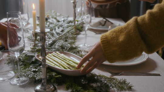 女人和朋友在圣诞晚餐时把食物放在节日餐桌