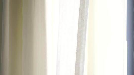 风吹窗帘窗户白色窗帘飘动阳光透过白色窗帘