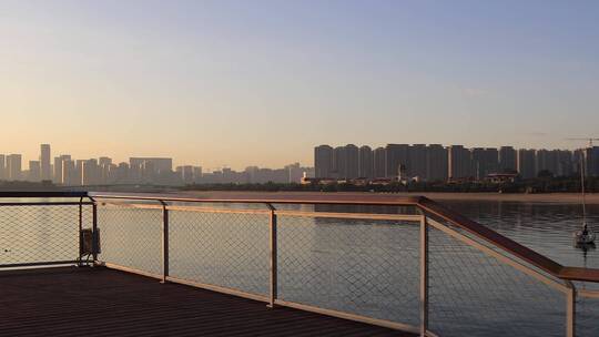 日出清晨宁静海湾栈道和城市建筑