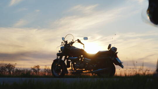 日落时分骑摩托车的人的剪影