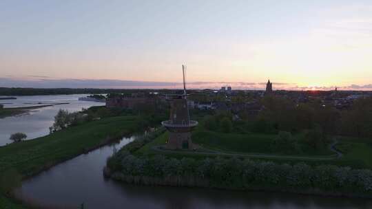 荷兰日落时风车和河流的鸟瞰图。