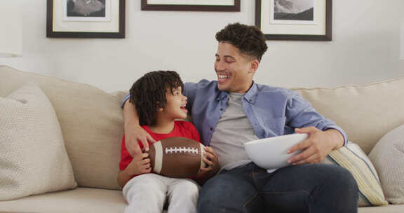 快乐的混血儿和他的儿子一起看美式足球比赛