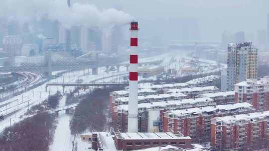 积雪城市中冒着浓烟的红白烟囱