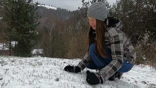 一个女人在雪地里和她的狗在户外玩耍