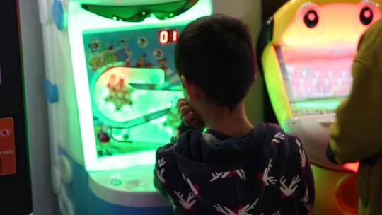 少年打游戏背影在游戏厅玩游戏 游戏机