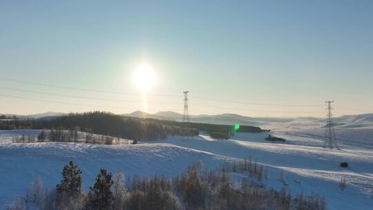 冬季大兴安岭丘陵地带雪原夕阳输电线路