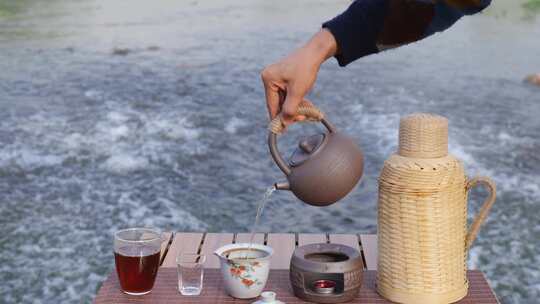 河边手艺人用茶壶倒茶场景