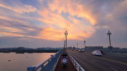 夕阳下骑电动车的人在南京长江大桥骑行