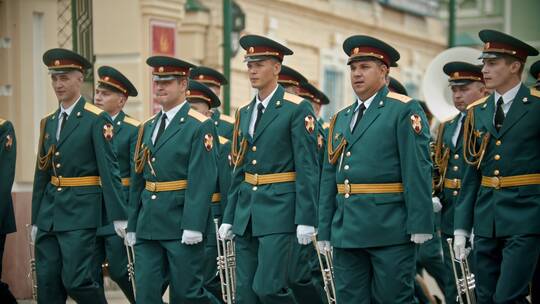 俄罗斯，喀山09-08-2019：管乐器游行-身着绿色服装的军事音乐家手持乐器在街上行进