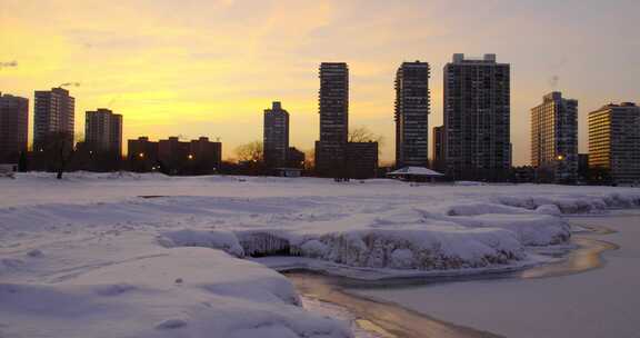 城市旁边的冰、雪和几乎结冰的湖