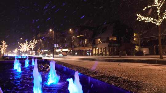 城市喷泉旁落满雪花的公路视频素材模板下载
