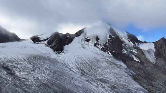 航拍四川甘孜云雾缭绕的乌库楚雪山风光