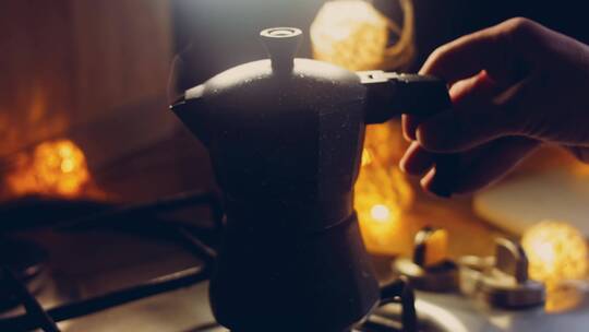 端起在灶上煮好咖啡的咖啡壶