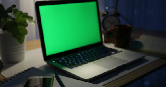 带绿屏的笔记本电脑。黑暗的办公室。多莉在。非常适合放置您自己的图像或video.Green正在使用的技术屏幕。色度键笔记本电脑