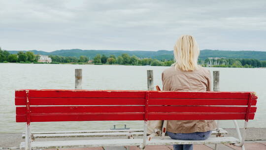 女人在长椅上欣赏湖泊