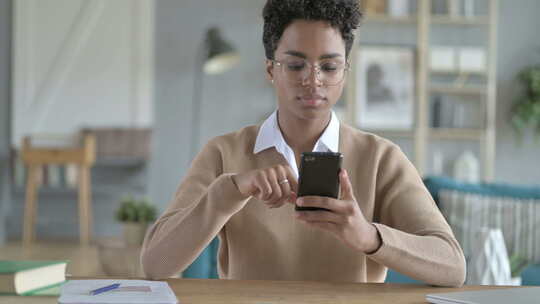 年轻的非洲女孩滚动她的智能手机视频素材模板下载