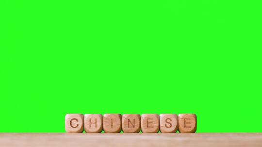绿幕背景前的中国人立方体木制字母块