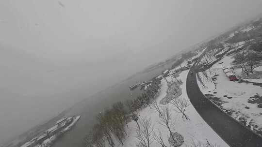 穿越机航拍北湖湿地公园雪景下雪古风建筑